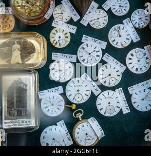 Vintage antique paperweights, watch and watch faces in display case. Stock Photo
