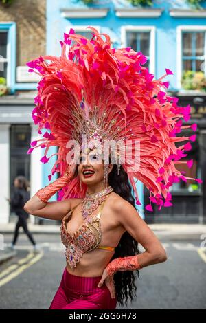 London, UK.  29 August 2021.  A samba dancer in colourful costume takes part in a flashmob around the West End organised by fashion brand RioPump GymWear.  The August Bank Holiday weekend would normally see tens of thousands of people watching events at the Notting Hill Carnival, including samba dancers, but, for the second year running, the carnival has been cancelled due to Covid-19 concerns.  Credit: Stephen Chung / Alamy Live News Stock Photo