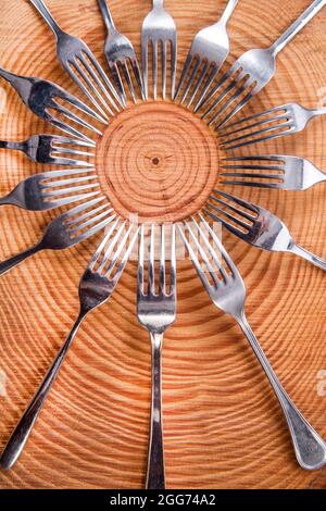 Series of different forks in a circle of pine board Stock Photo