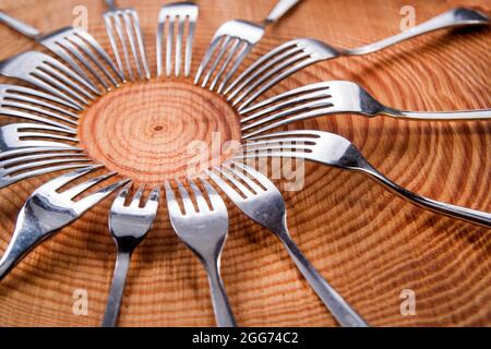 Series of different forks in a circle of pine board Stock Photo