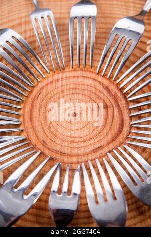 Series of different forks in a circle of pine board Stock Photo