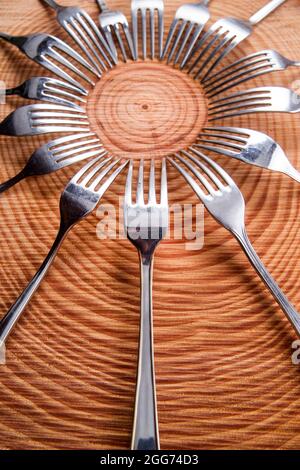 Series of different forks in a circle of pine board Stock Photo