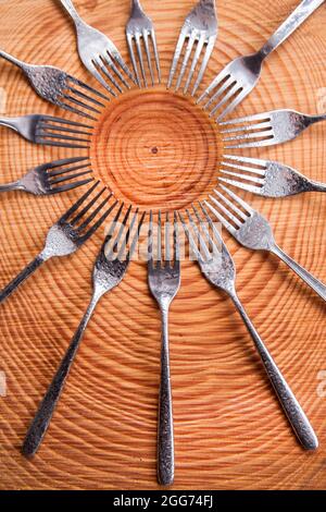 Series of different forks in a circle of pine board Stock Photo