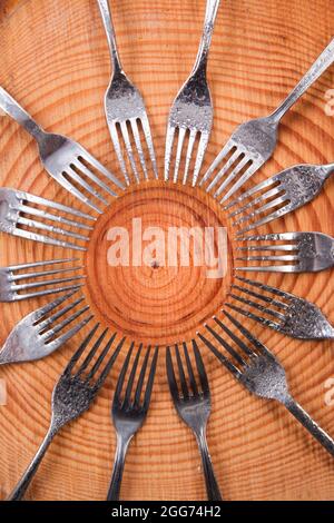 Series of different forks in a circle of pine board Stock Photo