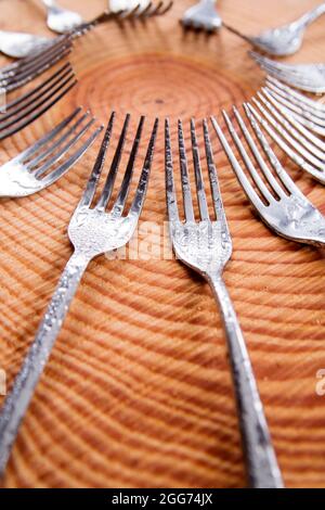 Series of different forks in a circle of pine board Stock Photo