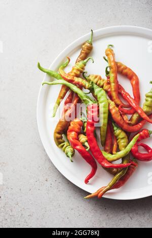 Fresh red and green peppers in a white dish. Stock Photo