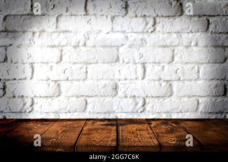 Background wooden table and white brick wall in the background, empty brown wooden table top for displaying products in the kitchen, shop, shop, cafe Stock Photo