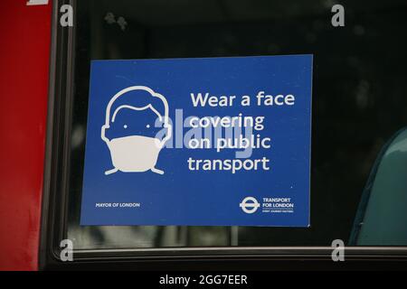 London, UK. 27th Aug, 2021. A 'Wear a face covering on public transport' sign seen displayed on a London bus. Commuters are required to wear a face covering when travelling on public transport. Credit: SOPA Images Limited/Alamy Live News Stock Photo