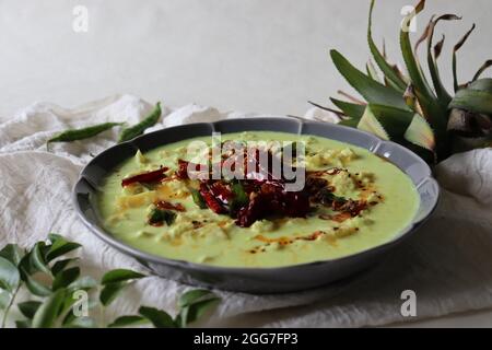 Pineapple pachadi. A yogurt based sweet and spicy curry made with pineapple, coconut, mustard seeds and curd. A side dish for Kerala meals. Shot on wh Stock Photo