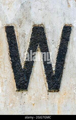 high texture letter W in black peeling paint on white background Stock Photo
