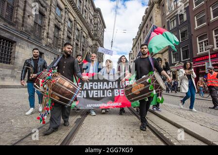 Protesters march through the Streets while playing drums during the demonstration. More than a thousand people gathered to demonstrate on Dam Square, to show their support for the recent plight of the Afghans', now at the mercy of the Taliban. The Dutch government has designated Afghanistan an unsafe country, meaning that refugees are entitled to protection and political asylum. Today's demonstration was organized by ‘Azadi', a movement of young Dutch Afghans, now part of an international movement ‘Stop Killing Afghans Now. The movement arranged 15 demonstration through-out Europe and American Stock Photo