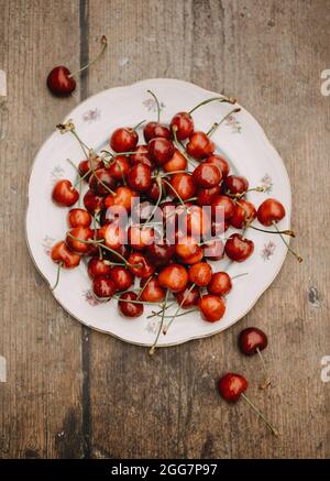 Bright, fresh cherries on a vintage plate on a wooden table Stock Photo