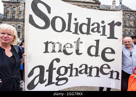 Protesters hold a banner expressing their opinions during the demonstration. More than a thousand people gathered to demonstrate on Dam Square, to show their support for the recent plight of the Afghans', now at the mercy of the Taliban. The Dutch government has designated Afghanistan an unsafe country, meaning that refugees are entitled to protection and political asylum. Today's demonstration was organized by ‘Azadi', a movement of young Dutch Afghans, now part of an international movement ‘Stop Killing Afghans Now. The movement arranged 15 demonstration through-out Europe and American citie Stock Photo