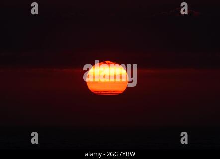 Red and orange glow of sunset over the Pacific Ocean. Cannon Beach, Oregon, USA. Stock Photo