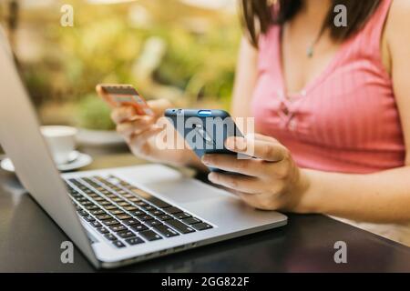 Young woman hands using credit card and mobile phone for online shopping Stock Photo
