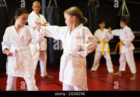 School girls practicing new karate moves in pairs Stock Photo