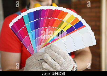 A man in gloves shows color swatches for repair Stock Photo