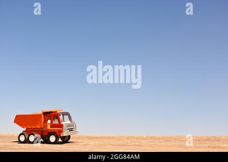 Toy tow truck. Collectible at scale. Wood floor and blue sky background. Macro Stock Photo