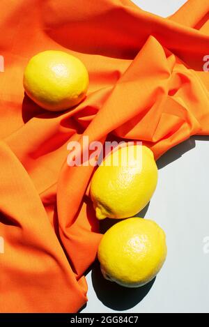 Studio shot of lemons and wrinkled orange table cloth Stock Photo