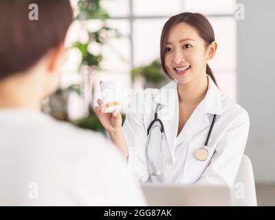 Smiling doctor showing pills to patient . Stock Photo