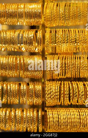 many golden jewel bracelet ring made of pure gold on jeweller display background Stock Photo