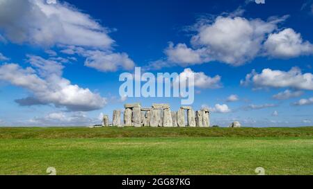 world famous stonhenge prehistoric stone circle monument on blue skygreen grass sunny background
