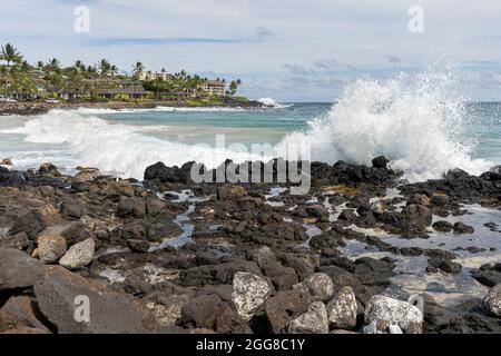Rough ocean waves break on the rocky shore of Poipu Beach Park in Poipu, Hawaii. Stock Photo