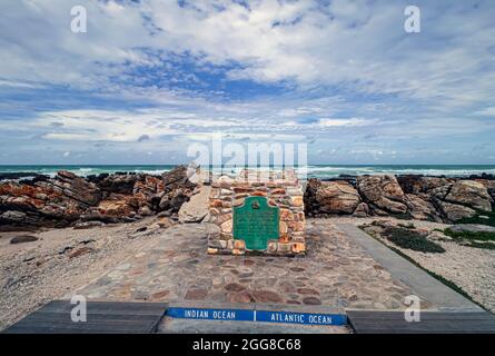 Stone monument marker that indicates the official dividing line between the Atlantic and Indian oceans at Cape Agulhas, South Africa. Stock Photo