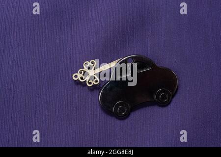 Black car keychain on a purple fabric background Stock Photo