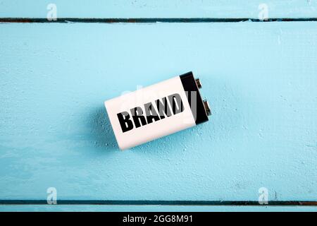 Brand concept. Battery on a blue painted wooden background. Stock Photo