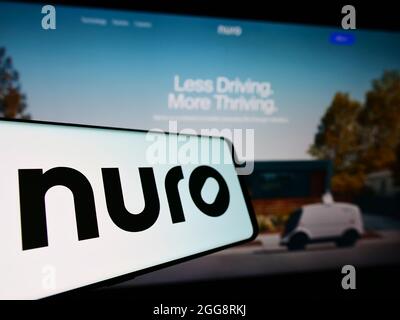 Mobile phone with logo of US robotics company Nuro Inc. on screen in front of business website. Focus on center-left of phone display. Stock Photo