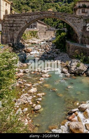 The ancient Pont Saint Martin bridge, in the historic center of the homonymous village, on a sunny day, Aosta Valley, Italy Stock Photo