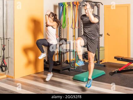 Athlete woman and man doing lunges jump exercises for leg muscle workout. Stock Photo