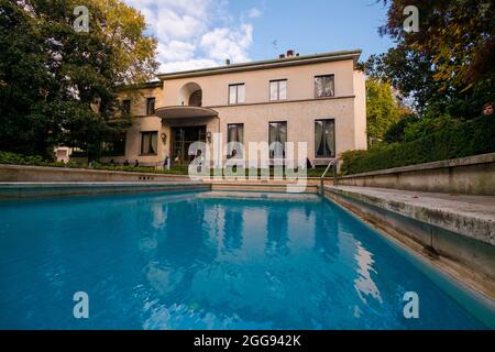 The front facade, entrance and blue swimming pool. At the industrialist mansion, Villa Necchi Campiglio, in Milan, Italy. Stock Photo