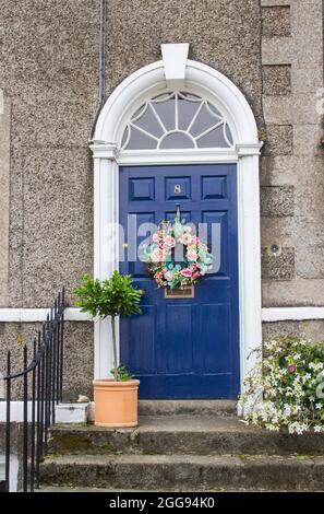 26 August 2021 A Geoargian styled panelled door and fanlight with a Colonial style concrete surround at the entrance to private accomodation on the ma Stock Photo