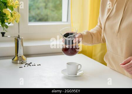 Unrecognisable woman pouring a coffee from glass coffee maker Stock Photo