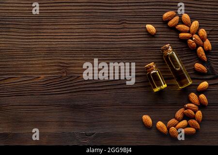 Almond nut oil in glass bottle with almond nuts. Extra virgin essence oil Stock Photo