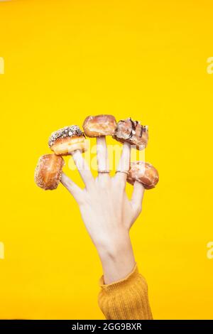 Five mini doughnuts placed on womand hands fingers Stock Photo