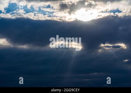 Rays of light shining throug dark clouds.Beautiful dramatic sky with sun rays.dramatic sky sun rays. Stock Photo