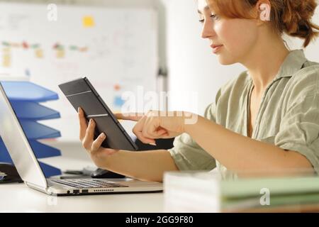 Concentrated woman working at office checking tablet content Stock Photo
