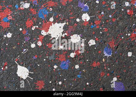 Paint blots and spots texture on black asphalt surface Stock Photo