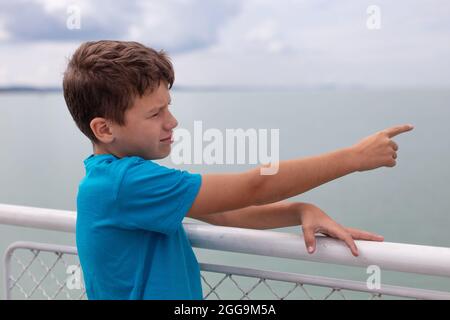 Little excited Caucasian boy showing point of interest on cruise ship Stock Photo