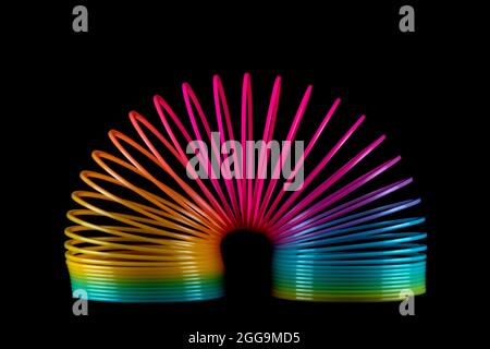 Colourful slinky spring toy isolated on a black background Stock Photo