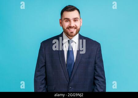 Portrait of young adult handsome businessman wearing official style suit looking at camera with toothy smile, expressing positive emotions and happine Stock Photo