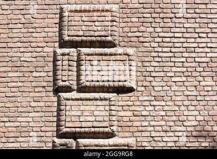 Wall of bricks. Geometric figures in relief made with bricks.Texture, background. Stock Photo