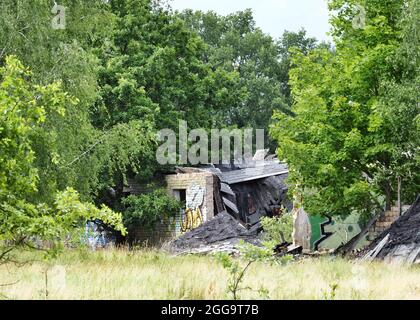 Oranienburg, Germany. 31st July, 2021. Dilapidated buildings of the former airport between Oranienburg and Leegebruch. The airfield was built in the 1930s and used by the Heinkel-Werke and the Luftwaffe of the Wehrmacht. After the end of World War II, Soviet occupation forces dismantled the facilities almost completely and used the remains of the factory airport as a military airfield. Around 2003, the newly built B 96 federal highway was built on a large section of the runway as Oranienburg's western bypass. Credit: Soeren Stache/dpa-Zentralbild/ZB/dpa/Alamy Live News Stock Photo