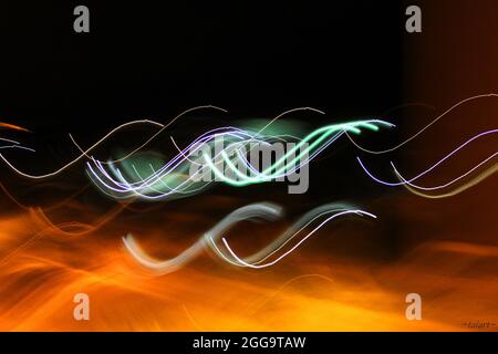 Abstract of waving neon lines on an orange and black background Stock Photo