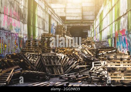 A pile of old wooden pallets on an abandoned warehouse Stock Photo