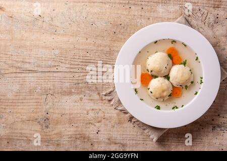 Traditional Jewish matzah ball soup on wooden table Stock Photo