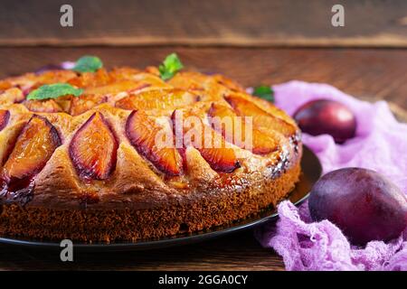 Delicious plum cake on wooden background. Homemade plum pie Stock Photo